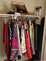 Photo showing a clothing rack with various women's jackets and tops including patterned and solid-colored items.