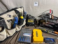 Photo of the Husky tool bag with assorted screwdrivers, DeWalt battery charger, Mastercraft screwdriver bit set, and other hand tools visible.