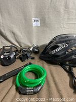 Photo showing the entire lot including bike pedal, derailleur, green combination cable lock, and the black Giro Havoc helmet.