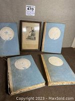 Photo showing four vintage psychology books with worn blue covers and white embossed medallions, arranged with a framed print behind them.