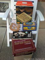Brio Labyrinth game box with child playing the game pictured, along with four other game boxes and a wooden cribbage board on a white chair.