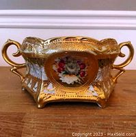 Side view of the hexagonal Nippon bowl showing two handles and overall gold gilt decoration with central floral motif.