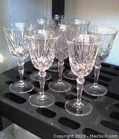 Set of 8 clear cut crystal long stem wine glasses with pinwheel pattern shown grouped on tray.