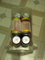 Box with 5 mini race cars in pop can shaped packaging, top view showing pull tabs and side netting.