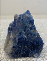 Front and side views of rough sodalite mineral specimen showing blue and white coloring and crystalline texture.