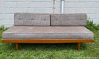 Full front view of daybed showing wood base and cushion arrangement