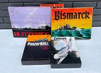 Photo showing four WWII-themed Avalon Hill vintage board games in bookcase-style boxes: Blitzkrieg, Bismarck, Luftwaffe, and Panzer Blitz.