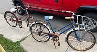 Photo of two vintage CCM bicycles side by side on driveway showing blue bicycle with front basket and maroon bicycle with traditional frame.