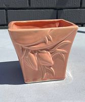 Front side view of the pink rectangular McCoy pottery planter with lily bud design showing the detail and condition.