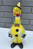 Full side-front view of the clown-shaped Murano glass decanter showing overall shape and colors.
