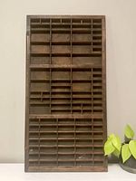 Front view of large wooden antique letter tray divided into multiple small compartments