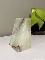 Front angled view of the alabaster bookend showing color patterns and chip on the side.