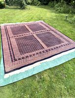 Full view of the rug laid flat on grass showing overall pattern and size