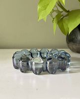 Side angle view of the blue bubble glass ashtray showing the rounded raised bubble rim detail and transparent deep blue colored glass.