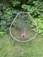 Front view of the vintage egg vinyl outdoor chair, showing the egg shape formed by vinyl strings and the metal frame base.