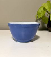 Blue exterior front view of the vintage Pyrex mixing bowl, showing rounded shape and smooth blue glaze.
