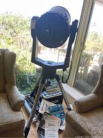 Assembled telescope on tripod showing tube, mount, case and manuals at base