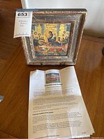 Framed Orthodox Christian religious icon with paper documentation placed below, showing the item and its story.