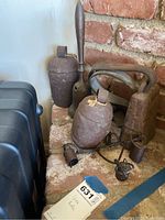 Wide view of three large iron bells and smaller cowbell frame on brick hearth