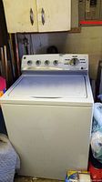 Full front view of white Kenmore washing machine in garage setting