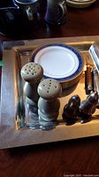 Square silver tray holding six Royal Doulton plates, salt and pepper shakers, and two Opinel cutters
