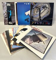 Photo of vinyl records arranged showing various album covers in a fanned pattern on a flat surface.