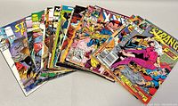 Photo showing a spread of 15+ vintage comic books featuring Dr. Strange, X-Men, and others in good condition