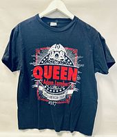 Front view of black Queen + Adam Lambert 2017 tour T-shirt with red and white graphic print.