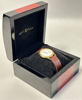Watch in black and red box with CERTA-LEVELS branding on the inside lid, Black cushion inside box holding watch.