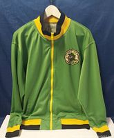 Front view of green track jacket on hanger, showing yellow zipper and black-yellow rib trim