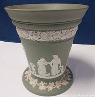 Front side showing classical white relief figures and floral garlands on sage green jasperware cache pot.