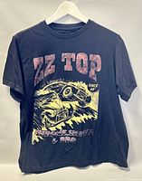 Front view of black ZZ Top T-shirt with graphic print of two vintage cars, smoke and flames, and text 'ZZ TOP','SINCE 69','CHROME, SMOKE & BBQ'.