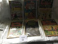 Six vintage comic books standing upright including Archie Girls Betty and Veronica, Annual, Pals 'n Gals, and holiday-themed titles.