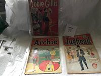 Three vintage comic books displayed, including Archie, Jughead, and Dobie Gillis titles showing age wear.