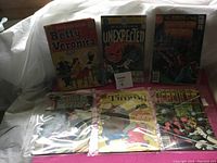 Six vintage comic books arranged and photographed on a flat surface, showing front covers: Archie Girls Betty and Veronica, DC Unexpected, Swamp Thing, Star Wars, Timmy, Hercules