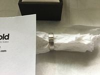 Ring displayed on white background with wrapper, showing polished white gold band and channel-set diamond row