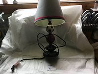 Photo showing full view of the lamp in a makeshift lightbox with the cord coiled at front.