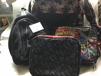 Photo showing the set of backpacks and lunch bags with some partial visibility of the superhero designs and camouflage print