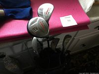 Photo showing a partial view of several junior graphite golf clubs including a Cobra Fly-Z S driver golf club in the bag, along with other clubs and the stand golf bag.