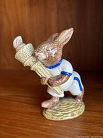 Front view of Bunnykins rabbit figurine holding an Olympic torch, clearly showing the detailed painting and sculpting.