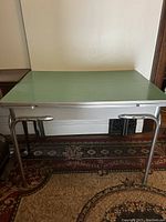 Full view of the mid century modern kitchen/dining table with green Formica top and metal legs