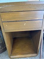 Night stand showing front open shelf and drawer exterior with minor wear and paint marks.