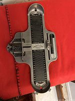 Photo of vintage metal shoe store foot sizing tool showing length and width measurements with sliding indicators and labeled left and right heel positions.