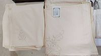 Folded table cloth showing delicate floral embroidery and an unused appearance.