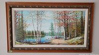 Full view of the framed painting showing the forest and lake landscape with birch and pine trees.