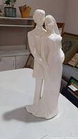 Front and side view of Royal Doulton Wedding Vows figurine depicting couple in formal wedding attire, glossy white porcelain.
