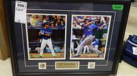 Full view of framed memorabilia showing two action photos of baseball player J.P. Arencibia in Toronto Blue Jays uniform with two pins and engraved name plaque.