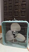 Front view of vintage Electrohome Long Life box fan showing metal frame, grill, blades, and central badge.