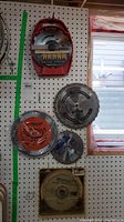 Photo of six various saw blades on pegboard including Sears Craftsman Excalibur and Orange Tornado.