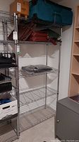 Chrome metal wire storage shelving unit in basement with some items stored on shelves.